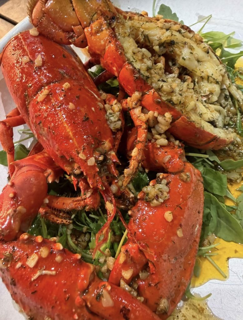 Lobster with garlic butter and rocket on a plate at Lookout on the Pier, Scarborough
